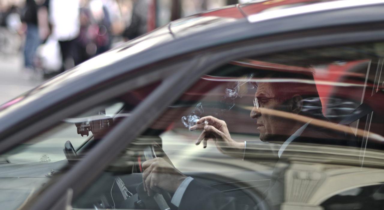 Conductor fumando mientras conduce un coche